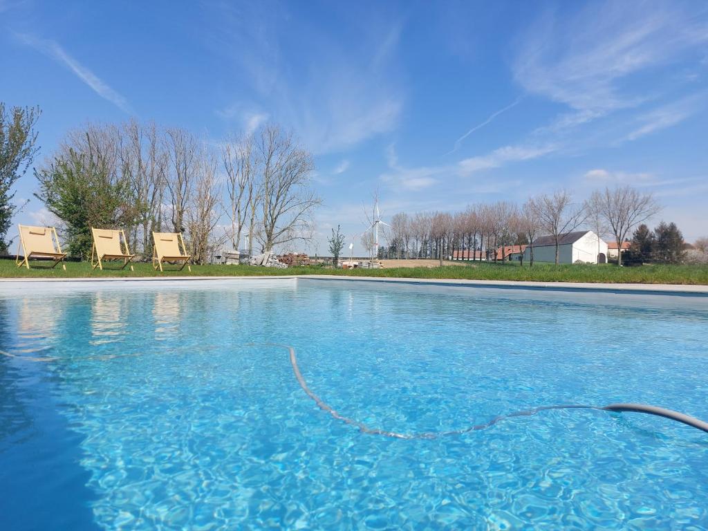 una grande piscina blu con due sedie di La Cense de Baudecet a Gembloux