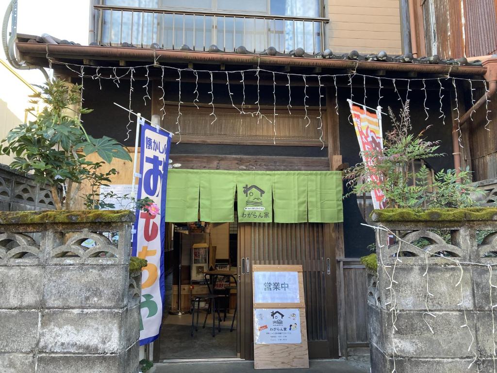 an entrance to a restaurant with flags and plants at wagaranchi in Kumano
