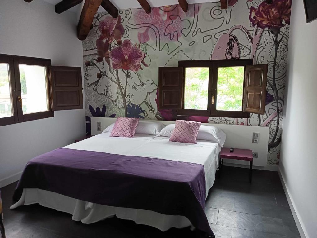 a bedroom with a large bed with a purple blanket at 1893 Hotel Boutique in Navajas