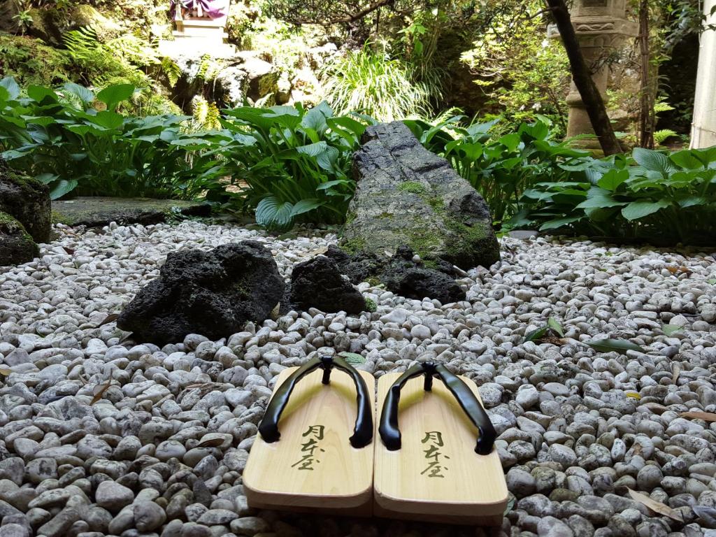 un par de zapatos sentados en un montón de rocas en Tsukimotoya Ryokan, en Toyooka