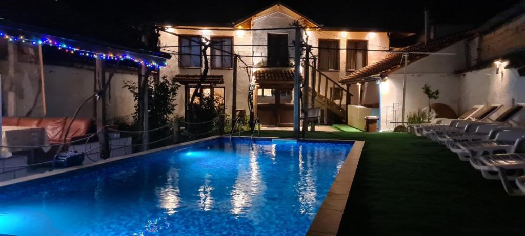 a swimming pool in front of a house at night at стаи за гости Никол in Starosel