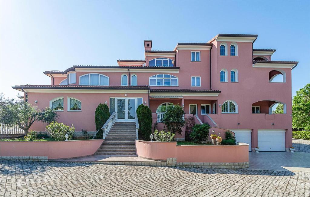 une maison rose avec des escaliers devant elle dans l'établissement Beautiful Apartment In Pavicini With Wifi, à Pavicini