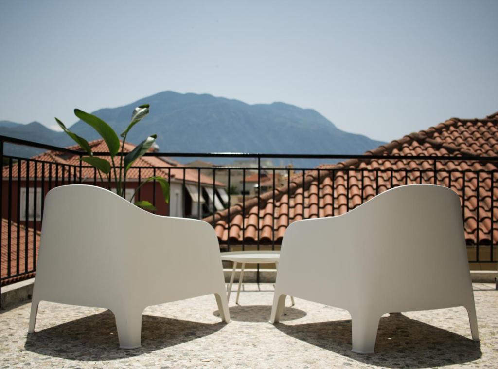 twee witte stoelen bovenop een balkon bij Onos - 2 bedroom 2 bathroom penthouse with terrace in Old Town in Kalamata