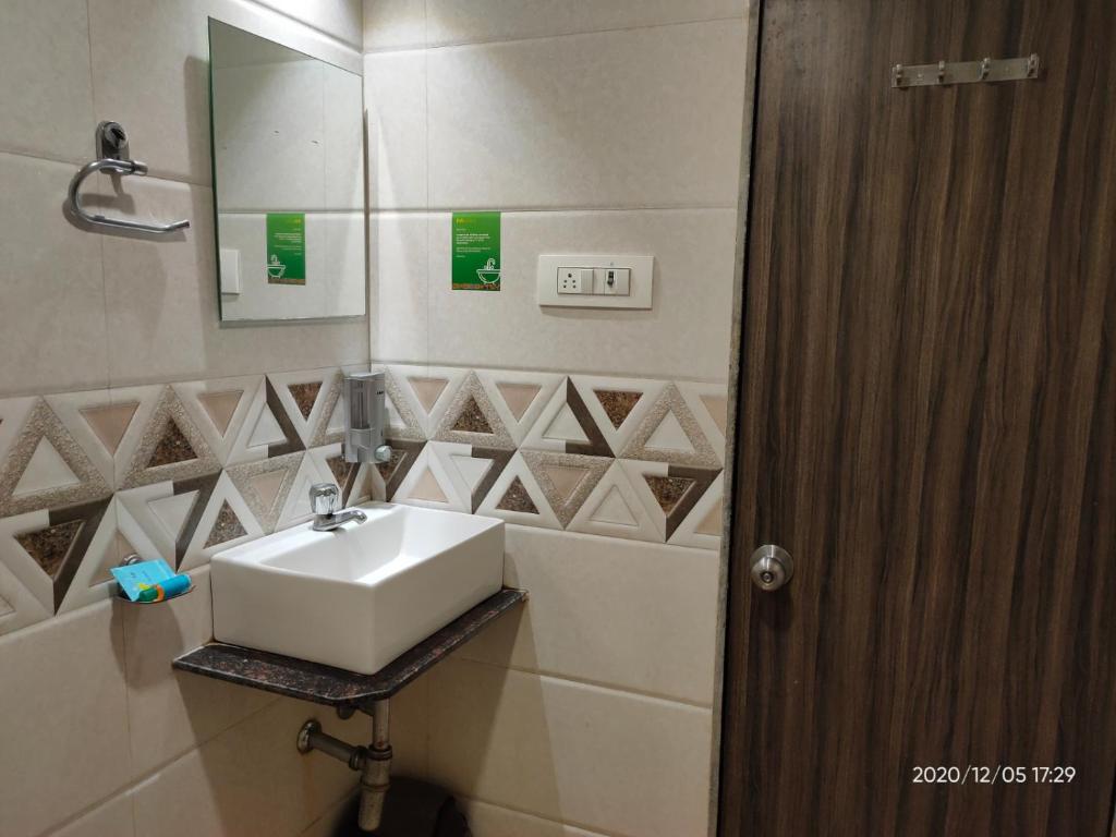a bathroom with a sink and a mirror at Orange International-SANTACRUZ in Mumbai