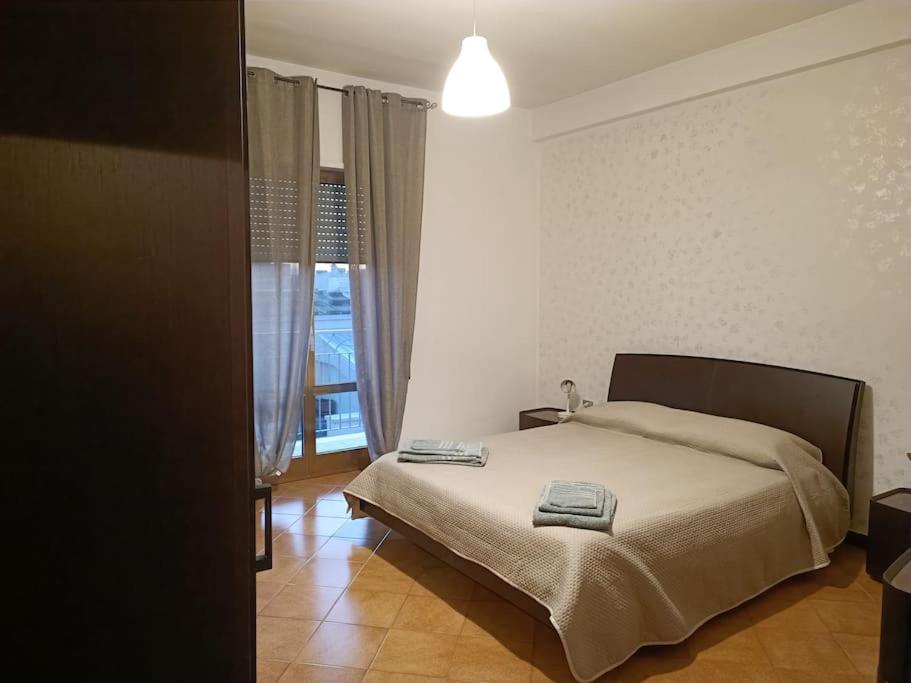 a bedroom with a bed and a large window at appartamento Alleria in Laterza