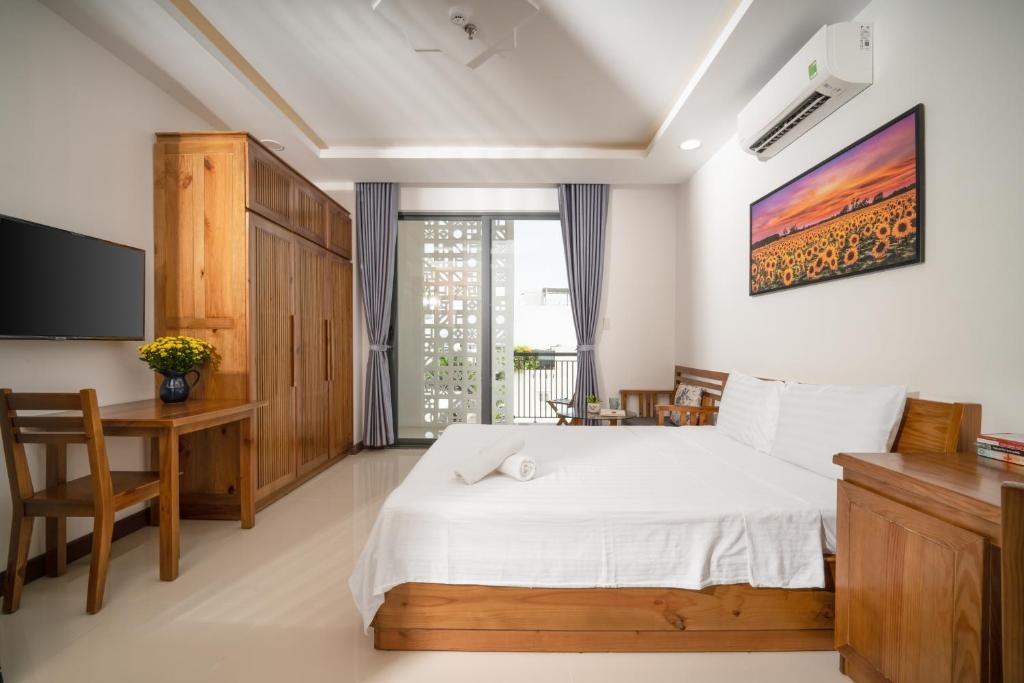 um quarto com uma cama, uma secretária e uma televisão em Carol Homestay & Apartment Đà Nẵng 4 em Da Nang