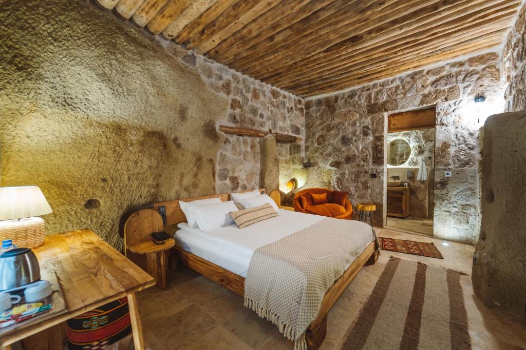 a bedroom with a bed in a stone room at Vie Cappadocia - Adults Only in Nevşehir