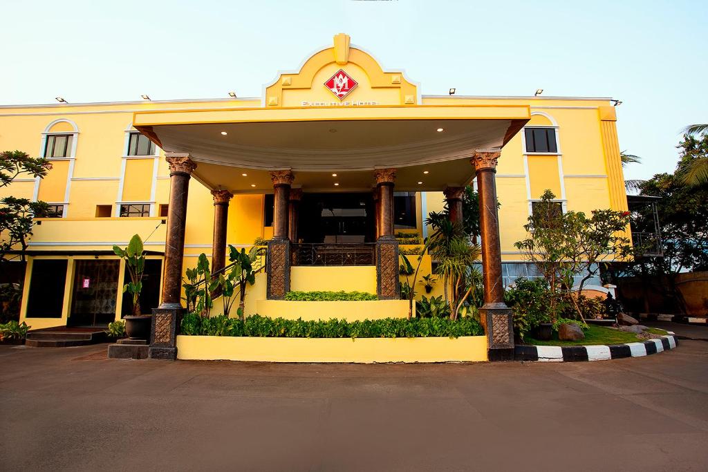 a yellow building with a porch in front of it at BI Executive Hotel in Jakarta