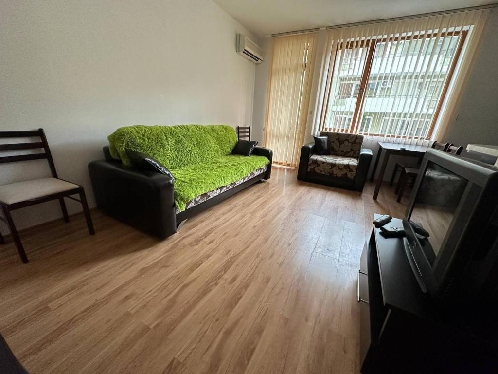 a living room with a green couch and a television at Siana 4 Apartment (15) in Sveti Vlas
