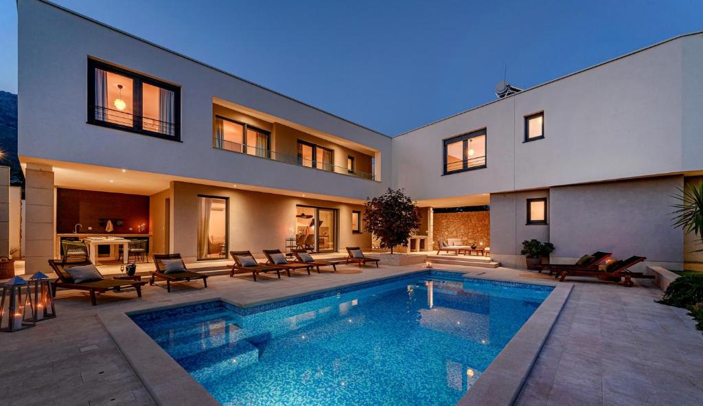 una casa con piscina frente a ella en Luxury villa Adris with heated pool, Gym, sauna - Split, en Kaštela