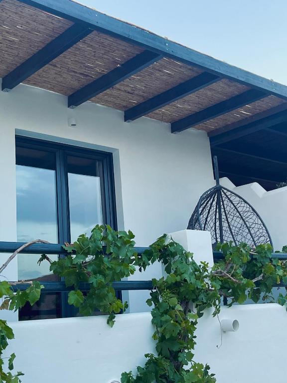 a balcony with a wooden roof and a plant at Vie rêvée luxury suites in Ganema