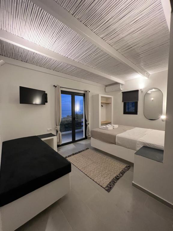 Vie rêvée luxury suites في Ganema: غرفة نوم بسريرين ونافذة كبيرة