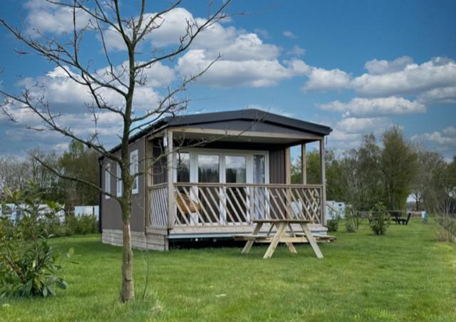 una pequeña cabaña en un campo con un árbol en Veld lodge en Schoonloo