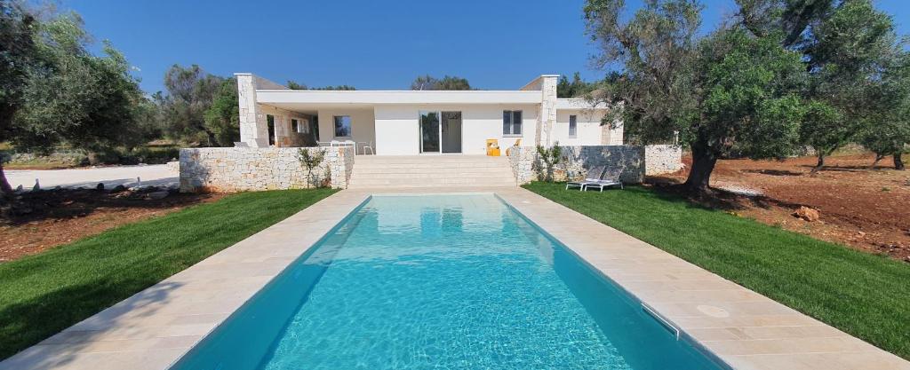 une villa avec une piscine en face d'une maison dans l'établissement HelloApulia La Perla di Torre Guaceto, à Serranova