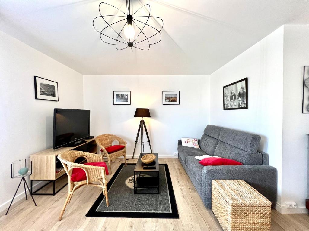 uma sala de estar com um sofá e uma televisão em T2 parking/climatisation - proche Halles au grain em Toulouse