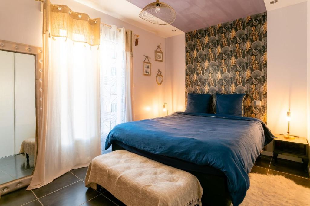ein Schlafzimmer mit einem blauen Bett und einem Fenster in der Unterkunft Charmante Villa Piscine/Jaccuzzi Béziers in Béziers