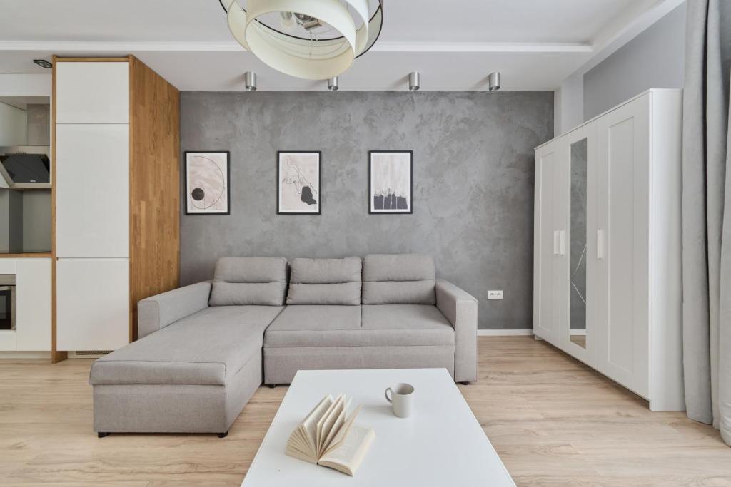 a living room with a couch and a table at Modern Studio with Balcony for 4 Guests in Wrocław by Renters in Wrocław