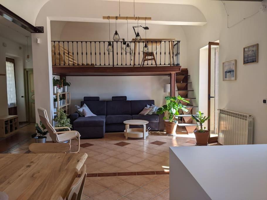 ein Wohnzimmer mit einem blauen Sofa und einer Treppe in der Unterkunft Il Casale la Lupa in Nunziata