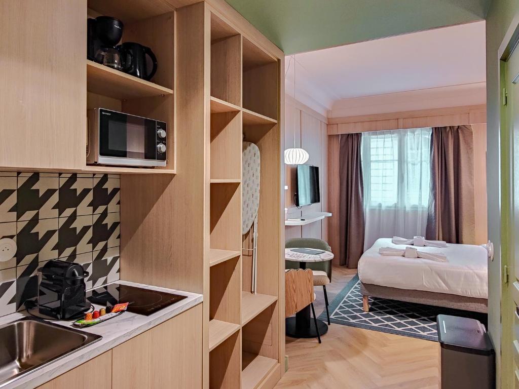 a hotel room with a bedroom with a bed and a kitchen at Aparthotel AMMI Nice Lafayette in Nice