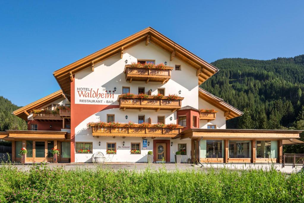 a building with balconies on the side of it at Hotel Waldheim in Valle Di Casies