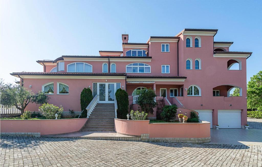 a pink house with stairs in front of it at Beautiful Apartment In Pavicini With Wifi in Pavicini