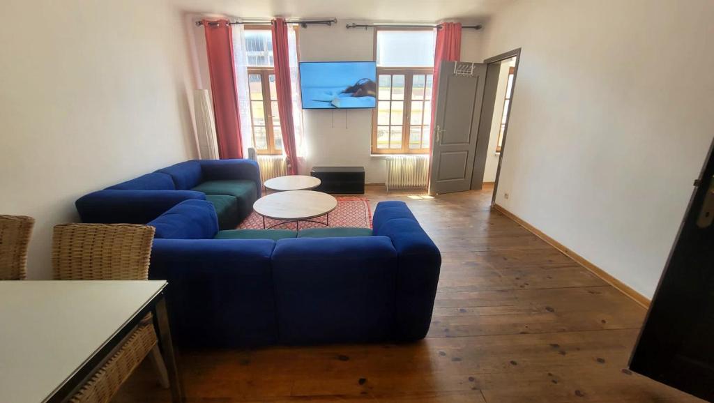 a living room with a blue couch and a table at 2 bedrooms appartement with wifi at Bruxelles in Bons Villers