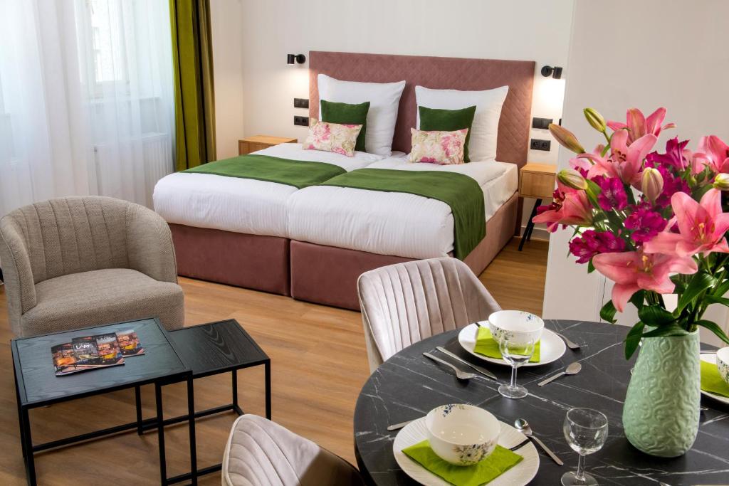 Habitación de hotel con cama, mesa y sillas en Rajska Residence, en Cracovia