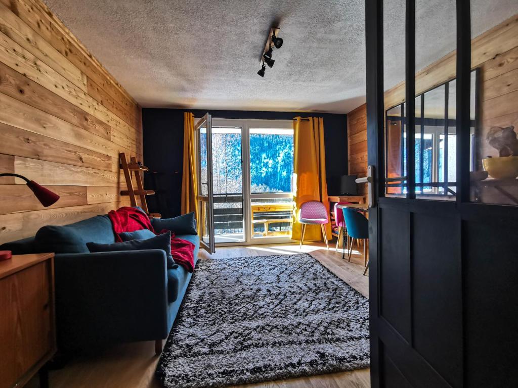 a living room with a blue couch and a window at Studio 4/5 personnes au pied des pistes Les Orres in Les Orres