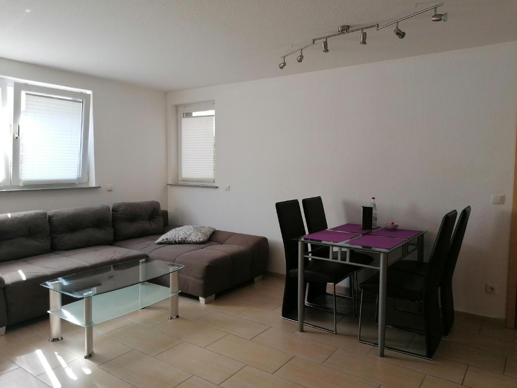ein Wohnzimmer mit einem Sofa und einem Tisch in der Unterkunft Ferienwohnung Weingut Brutscher in Roschbach