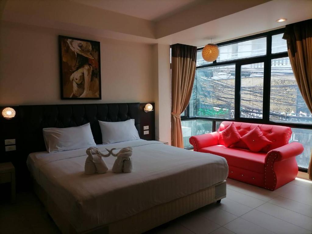 1 dormitorio con 1 cama y 1 silla roja en Amici Miei Guest House, en Patong Beach