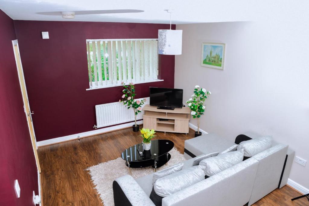 a living room with a couch and a tv at 87 Rawsthorne Avenue in Manchester