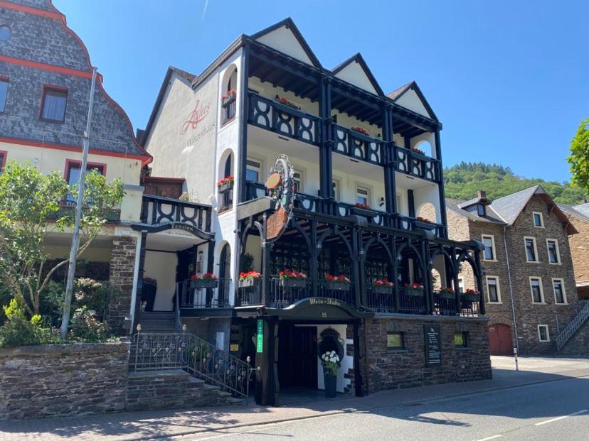 Um edifício com uma mulher à frente dele. em Altes Winzerhaus em Cochem