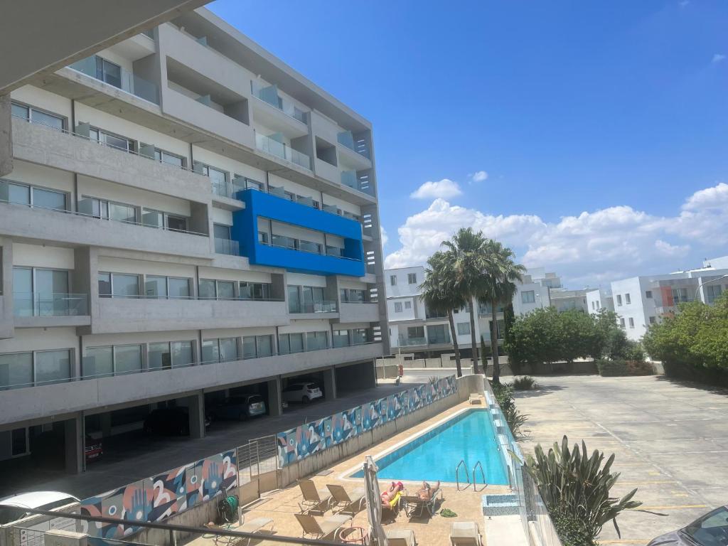 duży budynek apartamentowy z basenem przed nim w obiekcie UC Hall Residence w Nikozji
