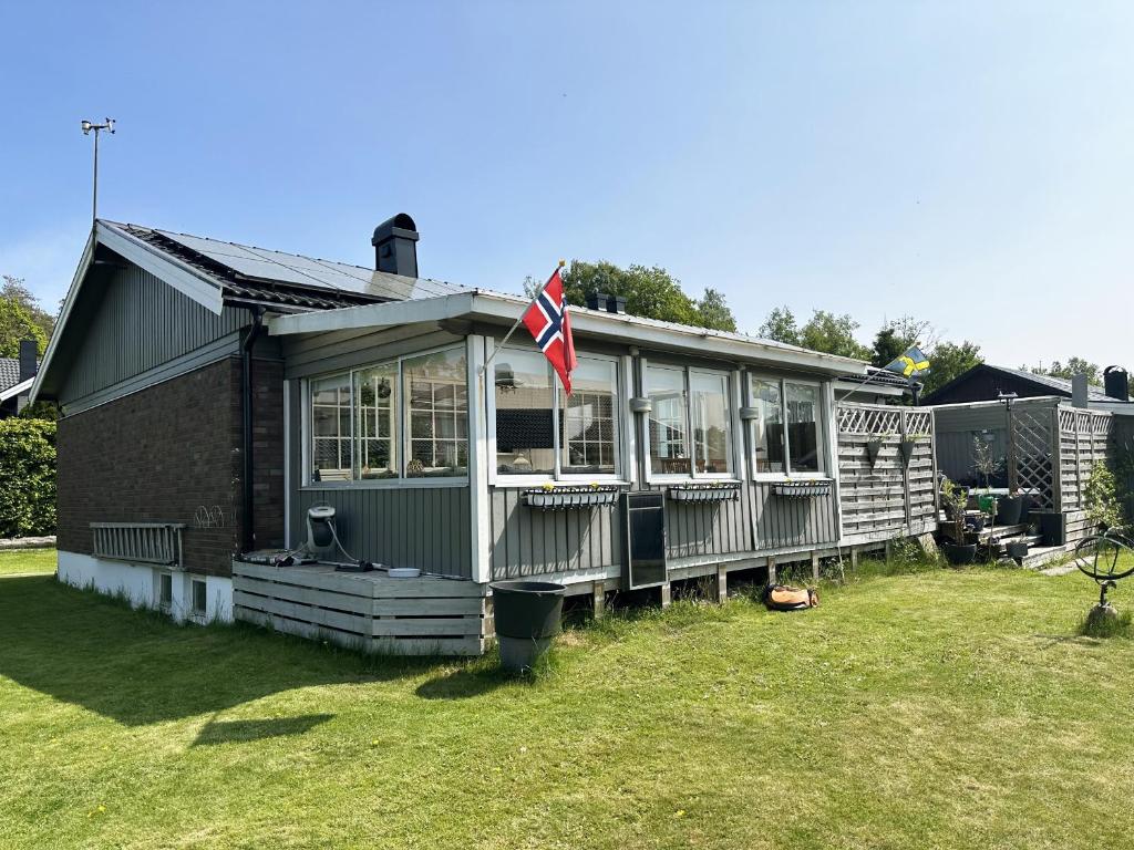 a house with a flag on the front of it at Unique villa with spa and sauna in Tanumshede in Tanumshede
