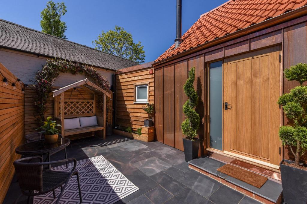 un patio al aire libre con un banco y un cobertizo de madera en The Hideaway, 