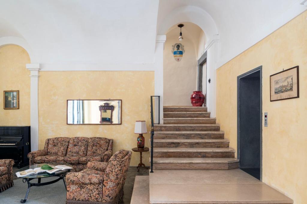 a living room with a couch and a staircase at Hotel Posta in Orvieto