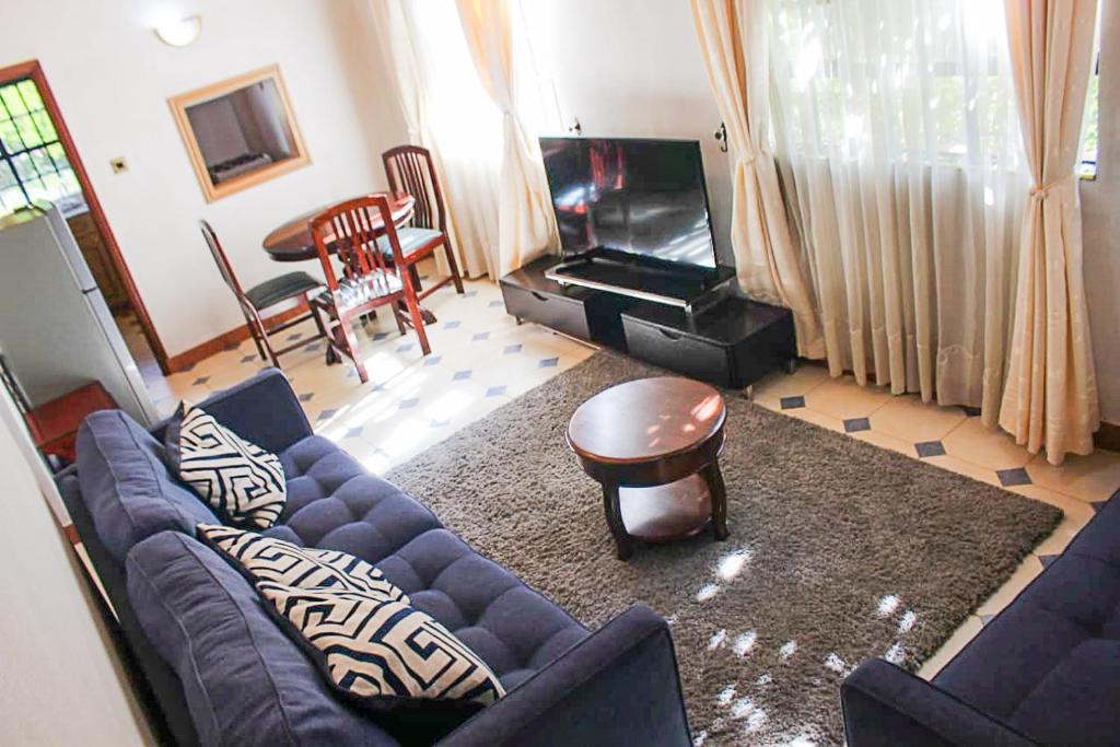 a living room with a blue couch and a piano at Windy Ridge Karen View Palace Apartment in Nairobi