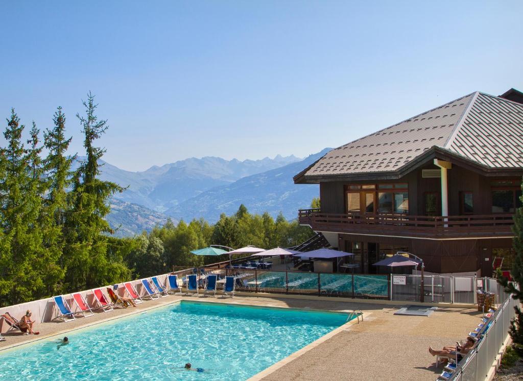 una piscina en un complejo con montañas en el fondo en VVF La Plagne Montalbert Paradiski, en Aime La Plagne