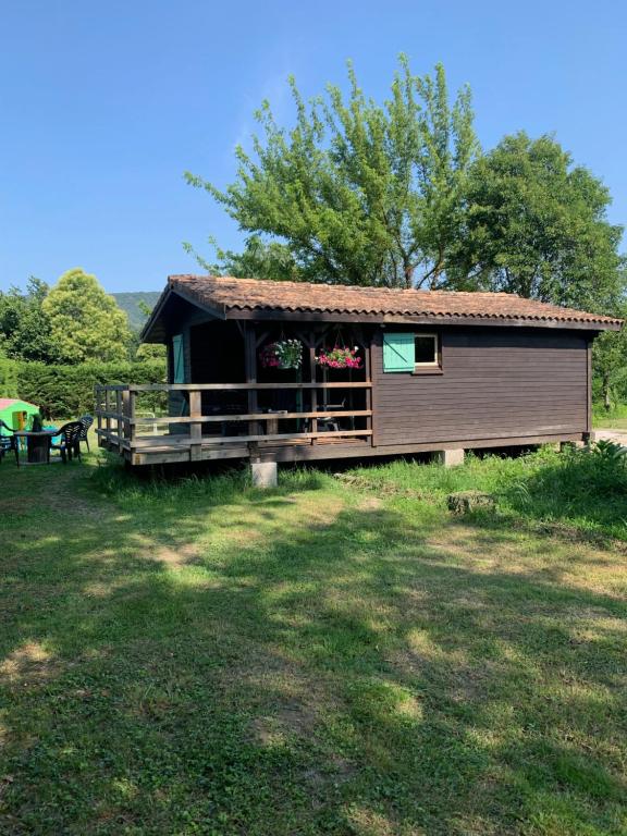 une petite cabine avec une terrasse couverte dans un champ dans l'établissement les petits chalets de DUDU, à La Voulte-sur-Rhône