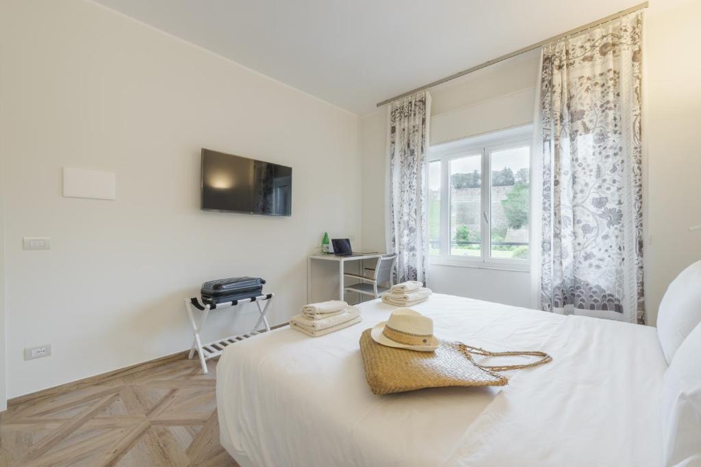 a white bedroom with a bed and a window at Supernova in Savona