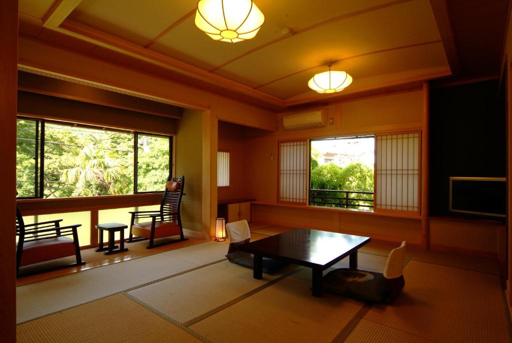 sala de estar con mesa y TV en Yusakaso, en Hakone