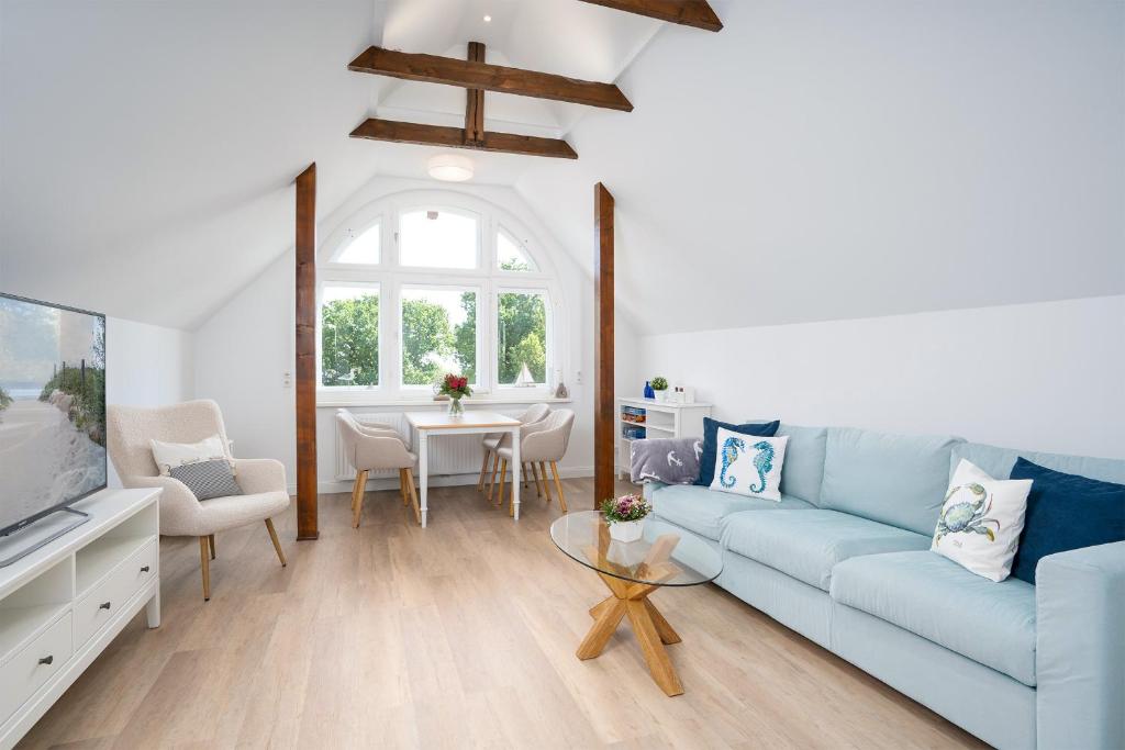 a living room with a blue couch and a table at KUR18 Ferienwohnung Baltic Deck in Timmendorfer Strand