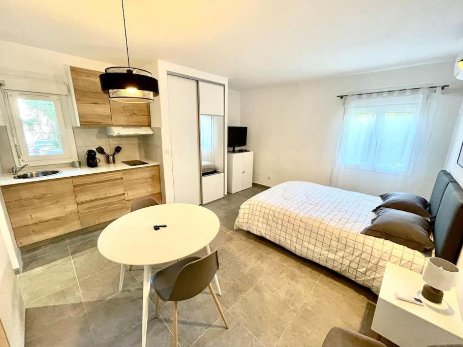 een slaapkamer met een bed en een tafel en een keuken bij Appartement Hypercentre Parking Gratuit in Ajaccio