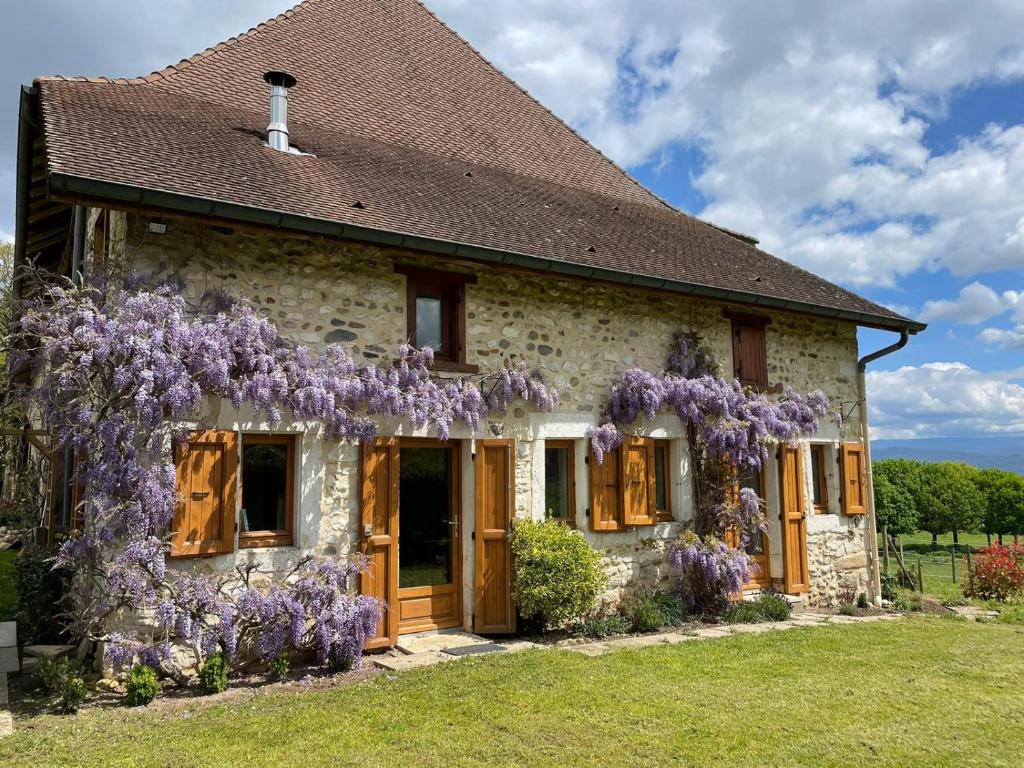 a house with wisteria on the side of it at La maison des commis in Morestel