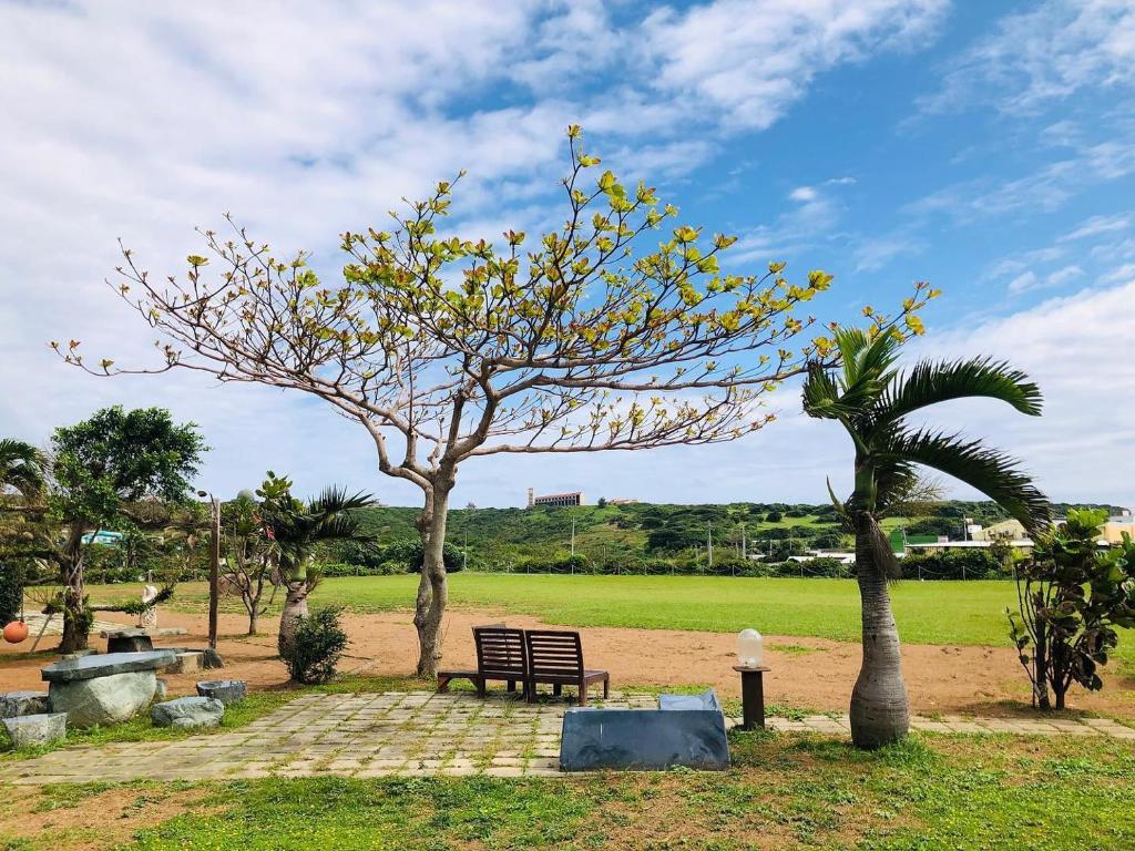 a park with a bench and a palm tree at Kenting Summerland Garden Resort in Eluan