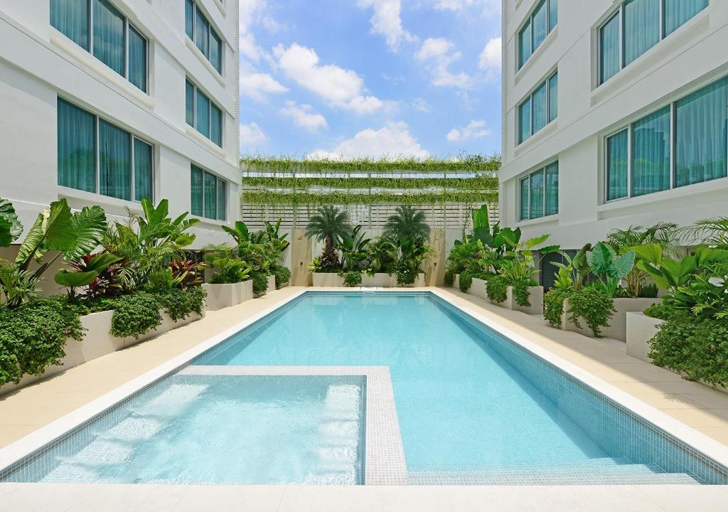a swimming pool in front of a building at Centre Point Sukhumvit 10 - SHA Extra Plus in Bangkok