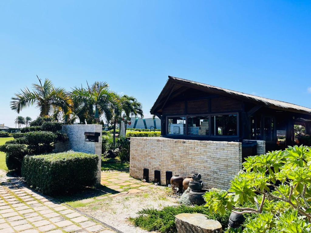 a brick building with a window in a garden at Kenting Summerland Garden Resort in Eluan