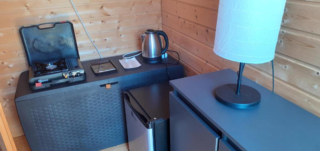 um quarto com uma mesa com uma televisão e um candeeiro em Domki letniskowe nad morzem em Pogorzelica