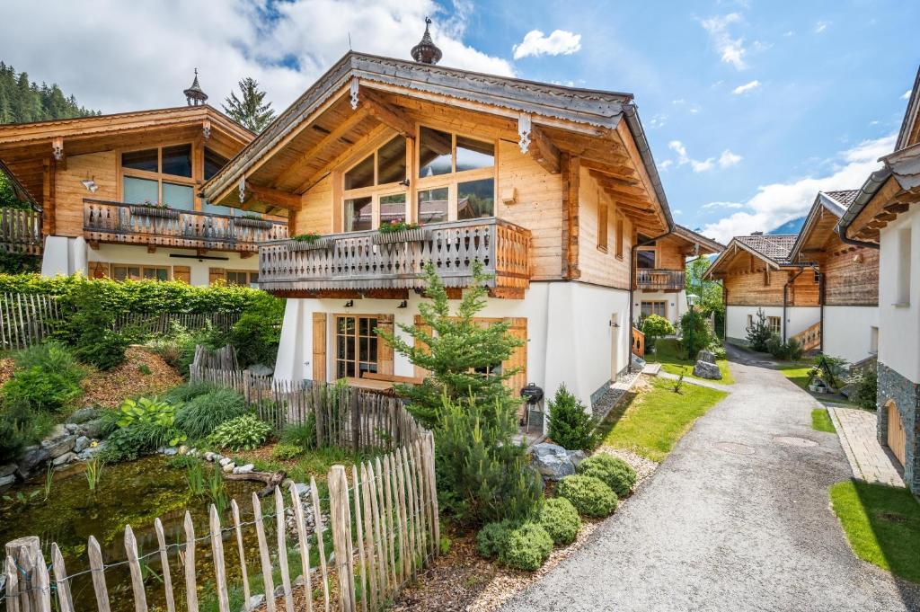 a log home with a fence in front of it at Chalet am Teich in Neukirchen am Großvenediger