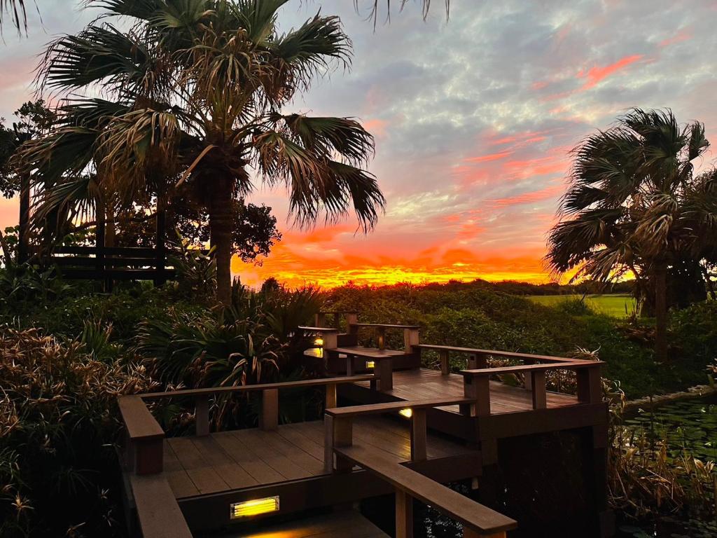 a wooden deck with a sunset in the background at Kenting Summerland Garden Resort in Eluan